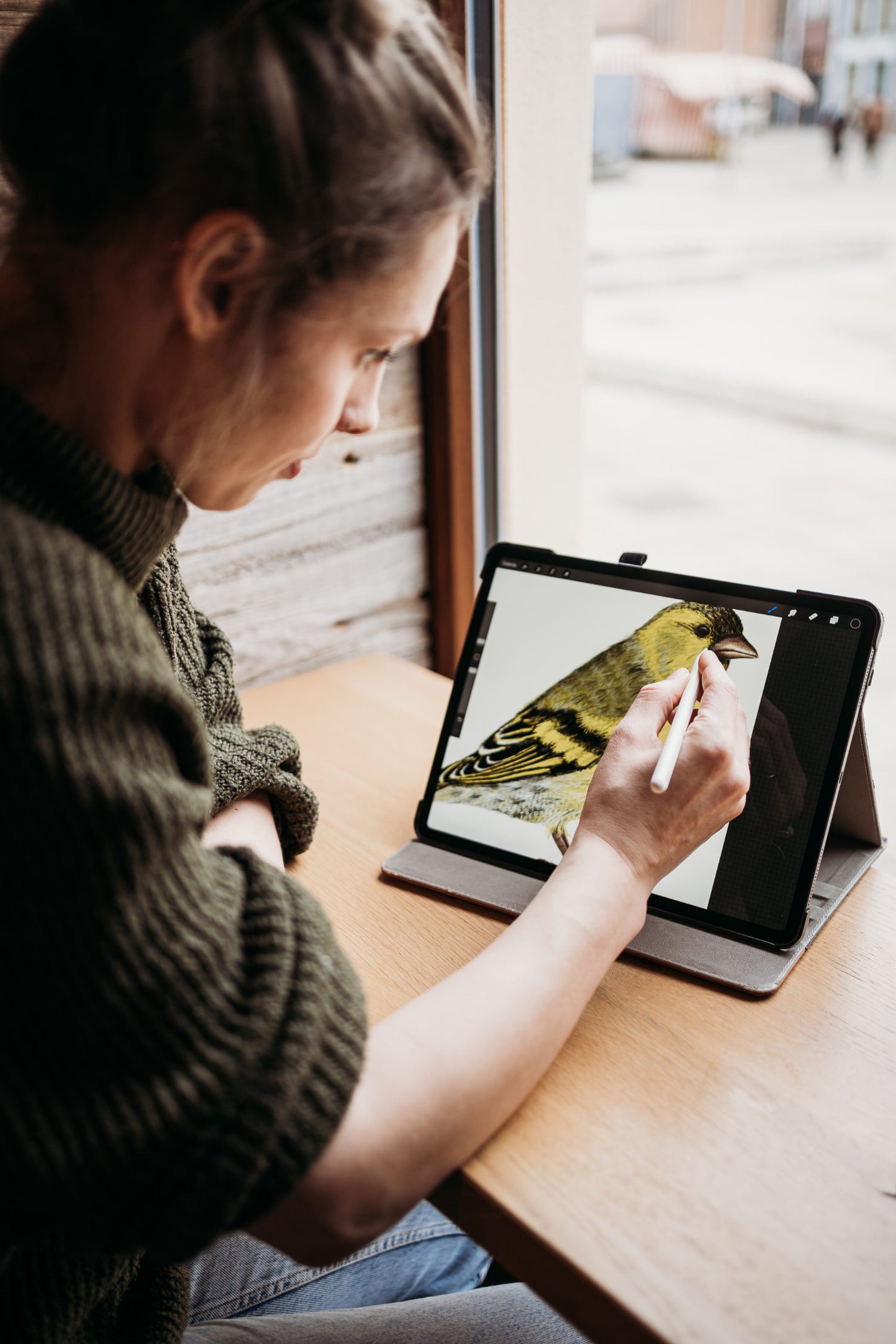 Illustratorin bei der Arbeit an einer Vogelzeichnung auf dem Tablet