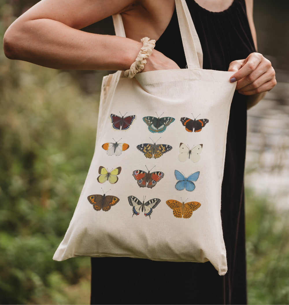 Bedruckte Baumwolltasche Schmetterlinge – Frau hält Stofftasche mit 12 Schmetterlingszeichnungen