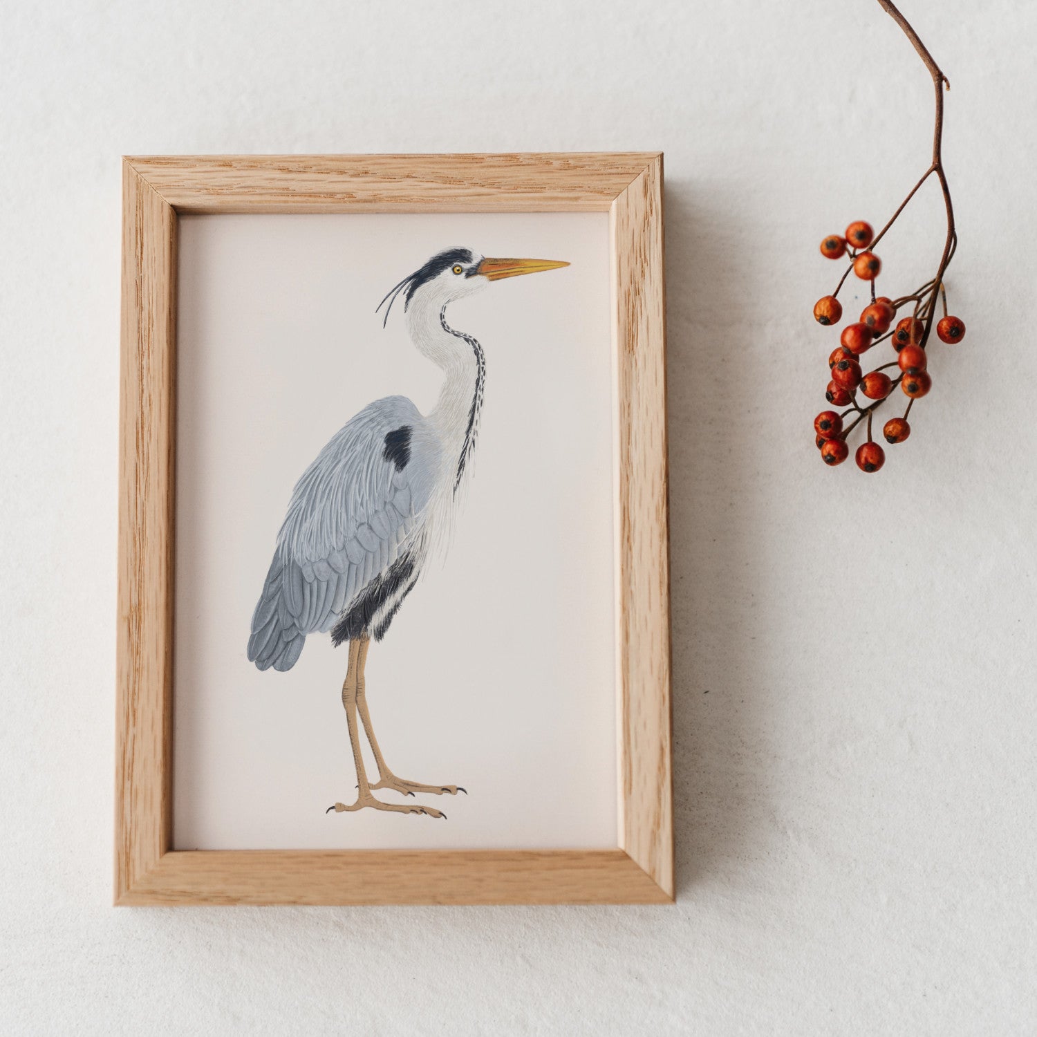 Graureiher Illustration im Holzrahmen mit getrockneten Beeren als Deko