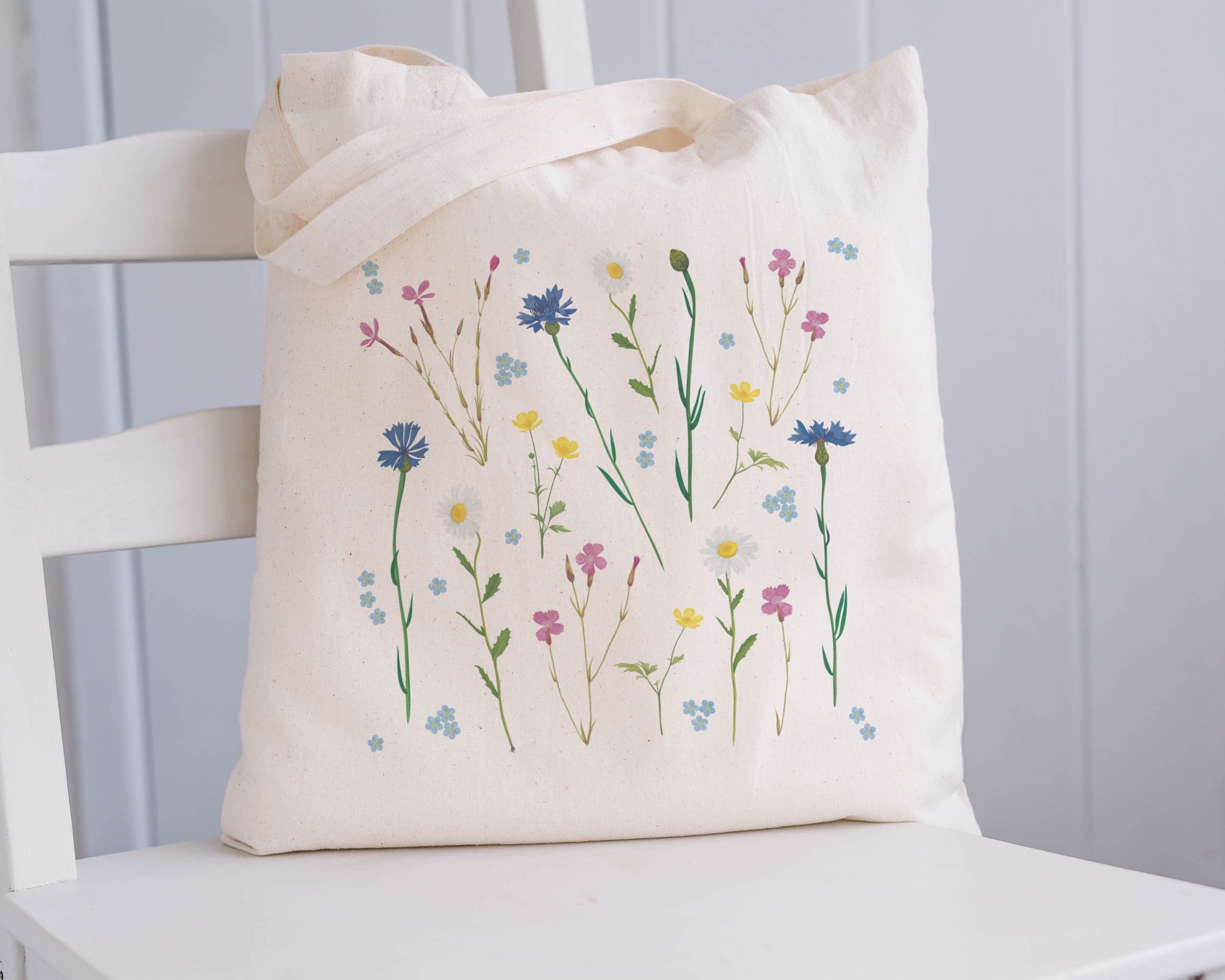 Stofftasche mit zarten Blumenzeichnungen auf weißem Stuhl